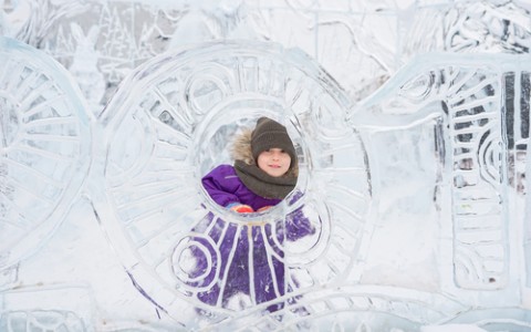 child hiding behind an ice sculpture
