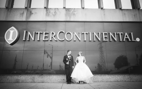 bride and groom in front of the intercontinental saint paul riverfront sign