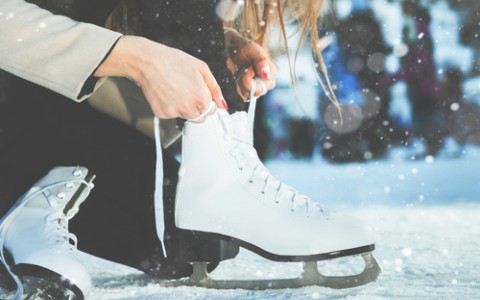 woman lacing up her ice skates