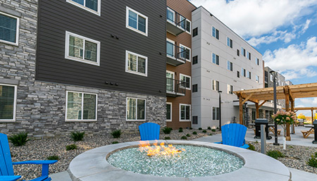 exterior of waterwalk hotel with fire pit and blue chairs