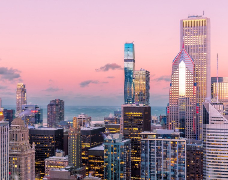 Tall buildings at sunset with lots of pink and blue colors in the sky.