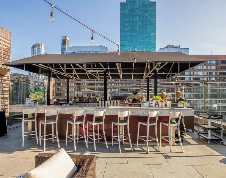 The sun shining over a rooftop bar and terrace,