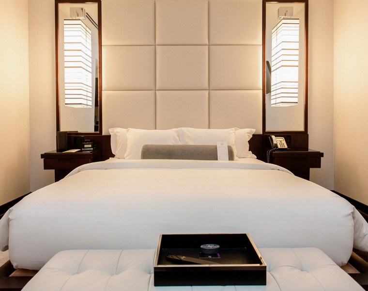 A large white bed with black nightstands.