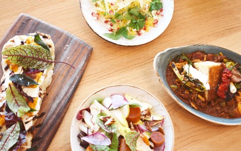 flatbread, salads, and chili on a table