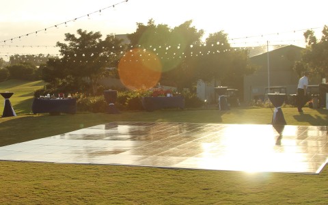 a dance floor outside on the golf course as the sun is shining