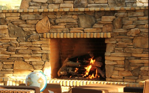 close up of the outdoor fireplace and a seating area 