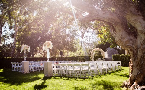 an outdoor wedding with lots of trees and the sun shining