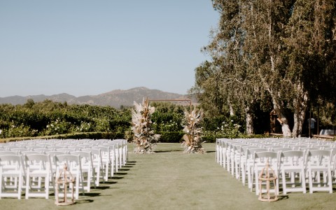 rows of white chairs on the lawn with the mountains in the distance