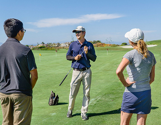 a golf instructor speaking to a group of people learning to golf