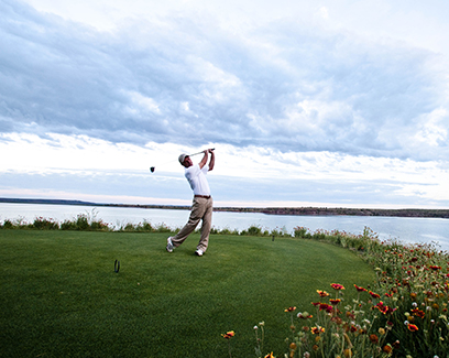 a man finishing his swing on 12 shores course 