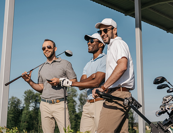 three smiling men posing with their golf gear