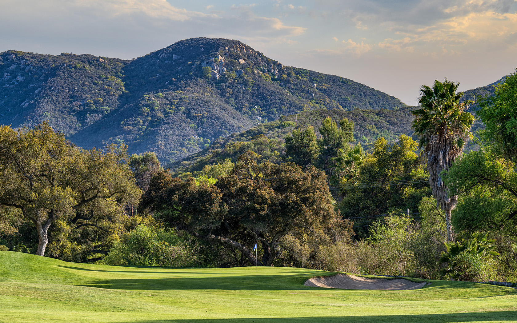 close up of the small hills and tall mountains located just beyond the golf course
