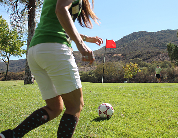 a girl wearing a green shirt playing footgolf