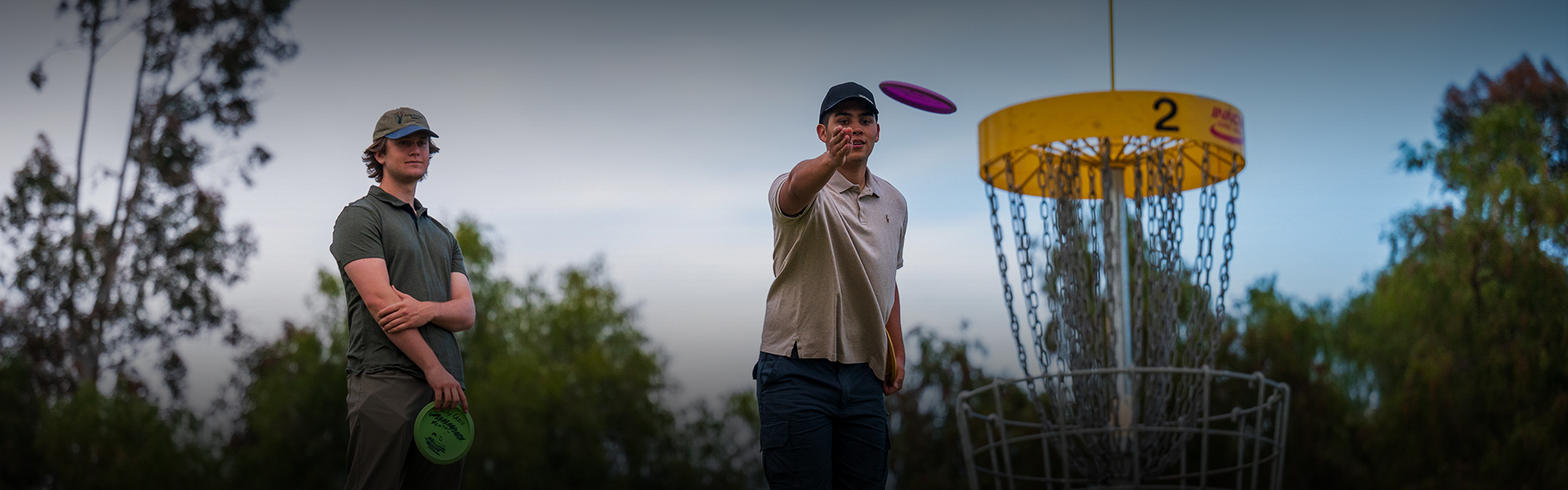 two men looking straight ahead at the number two target for discgolf