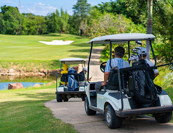 two golf carts parked on the path with golfers sitting in them