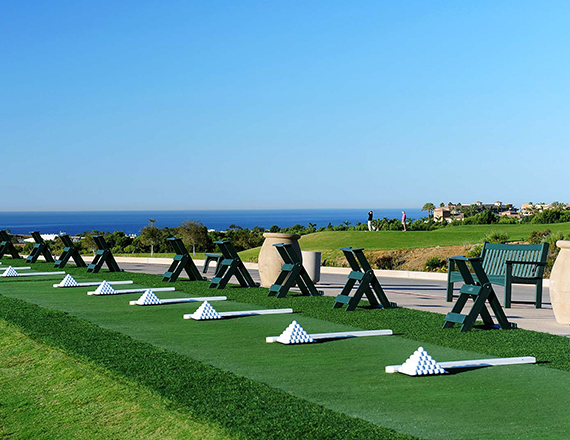the driving range with dark green benches and golf balls stacked neatly