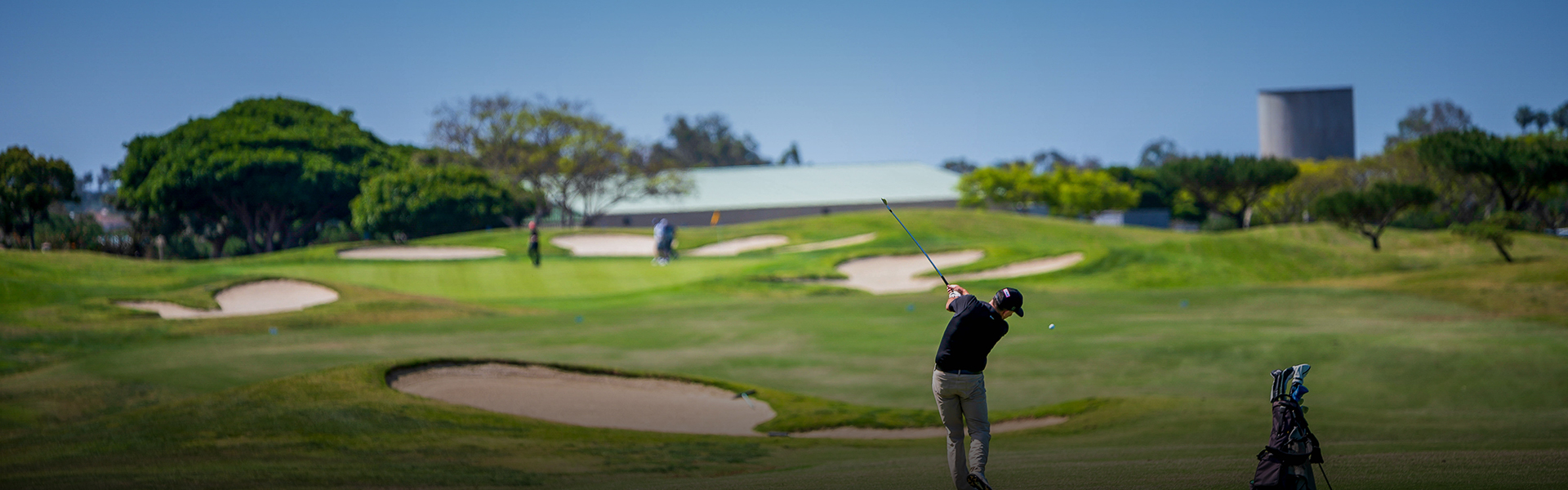 a man playing golf in an area with many sand dunes in his view