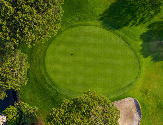 drone shot of a putting green with the sun shining 