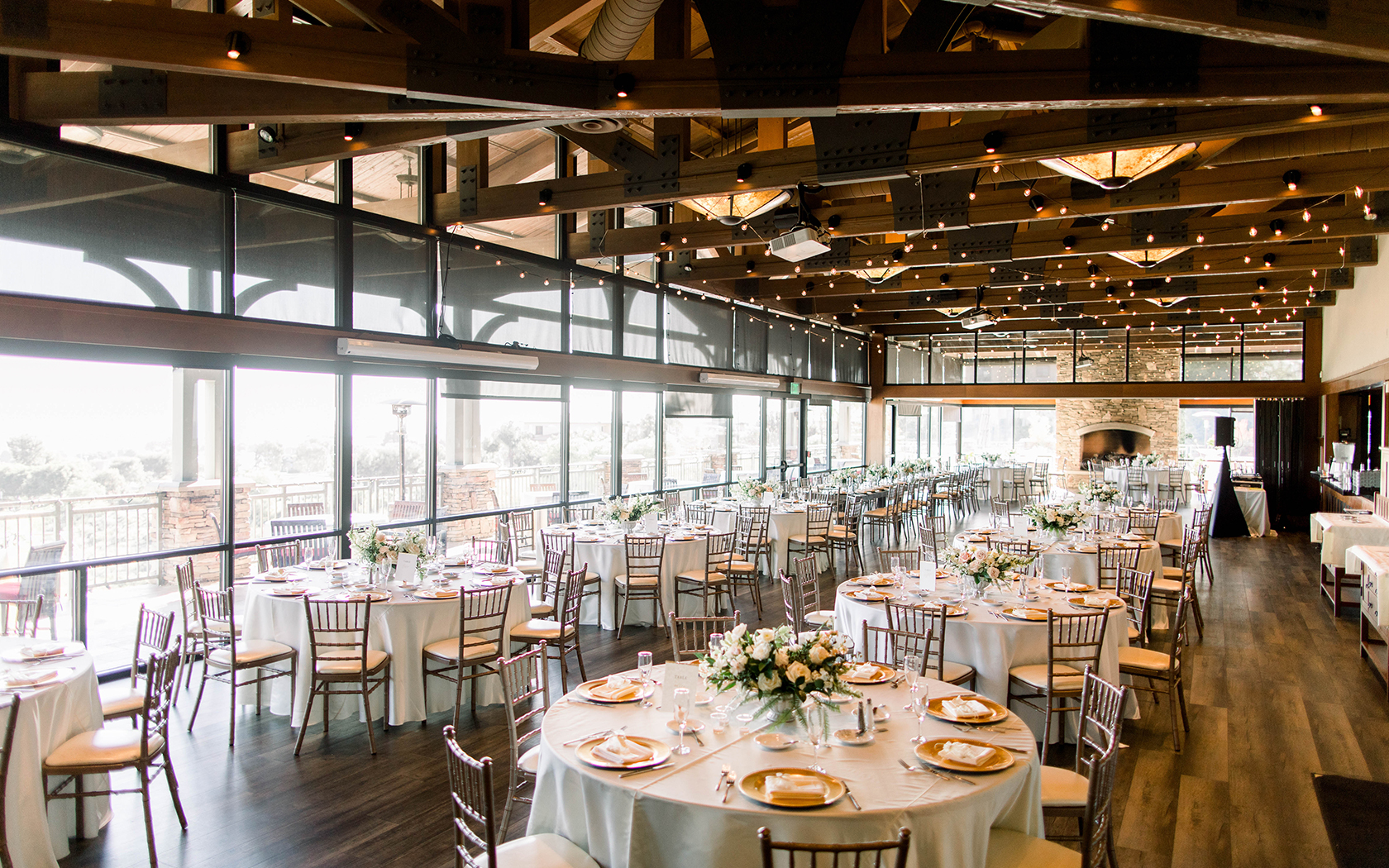 a large event space with many linen covered tables and low lighting
