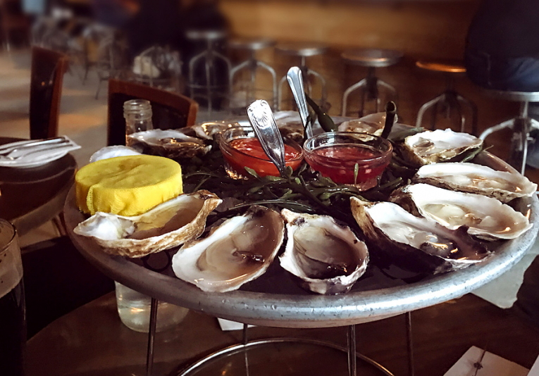Oysters on tray with dipping sauce & lemon wedges