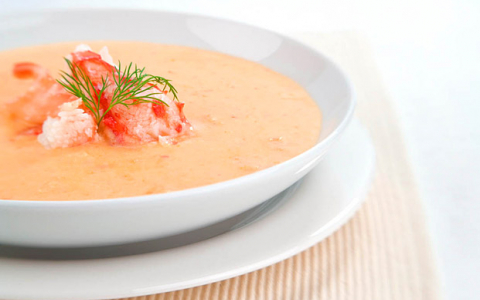 Light orange soup with herbs in the center