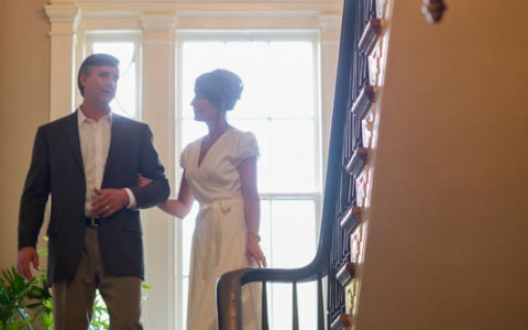 man and woman walking in an entrance holding hands.