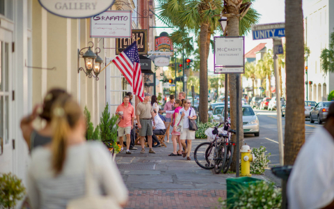People walking by shops down a street in Charleston