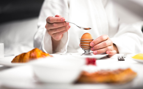 Chef placing hard boiled egg in wire holder