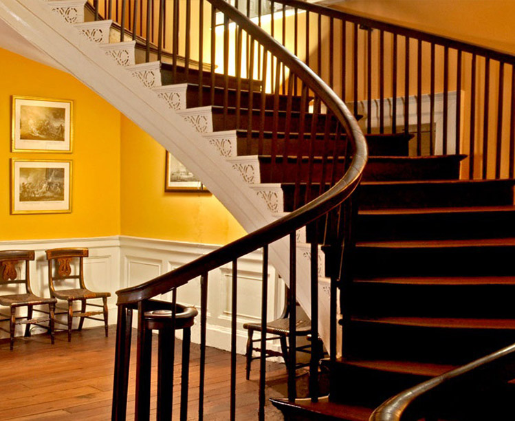 dark wooden staircase featuring a mustard colored room