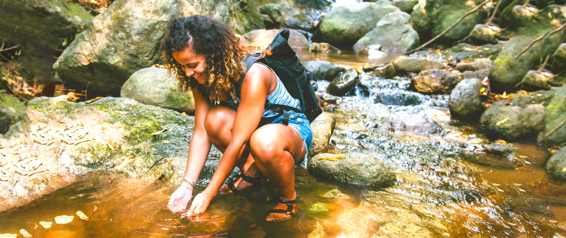 woman standing in a stream rinsing her hands