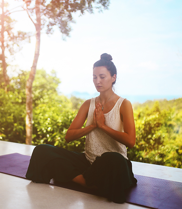 woman meditating in a tropical setting