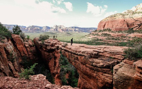 red canyon with a person standing in the middle of it 