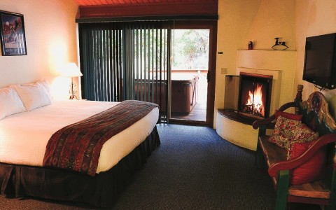 a fireplace in a hotel room with a door to the balcony