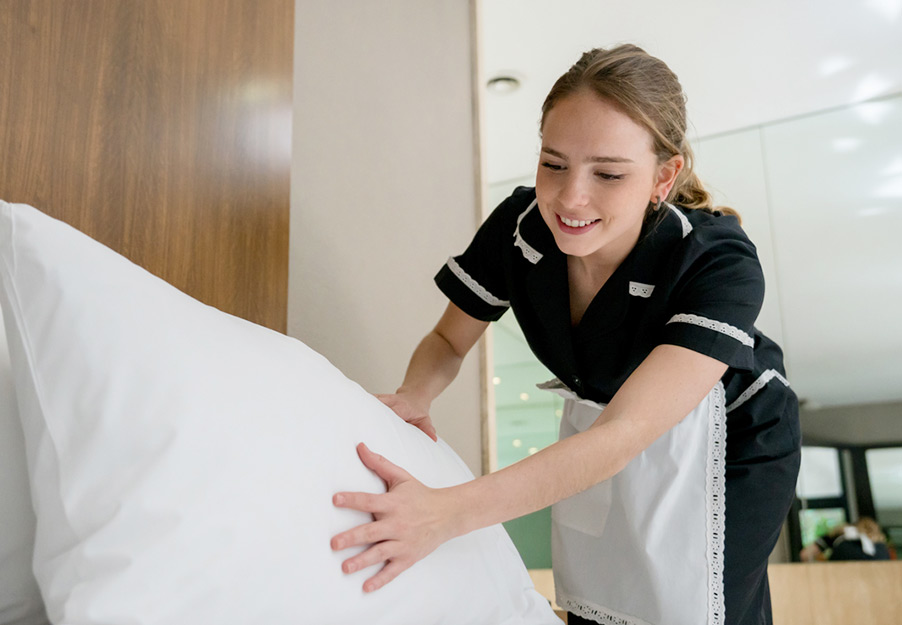 housekeeper fluffing pillows