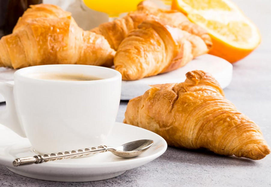 Breakfast tray with two croissants, orange juice and french press coffee