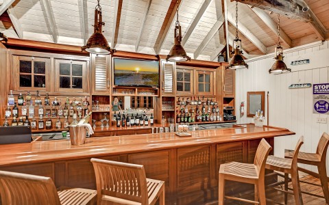internal view of a restaurant bar with bottles on shelves in the background
