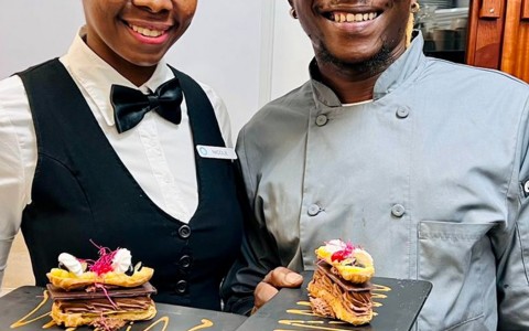 image of server and chef holding a tasty creation served on a black tray