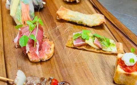 display of small appetizers served on wooden plate