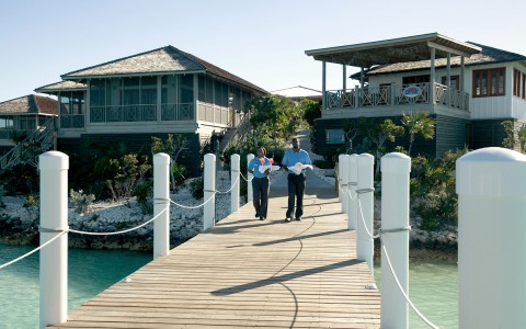 Front view of the property's wooden bridge and two service people approaching 