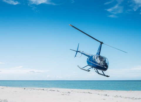 an image of a helicopter taking flight off the beach