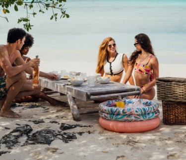 group of friends enjoying a picnic on the beach