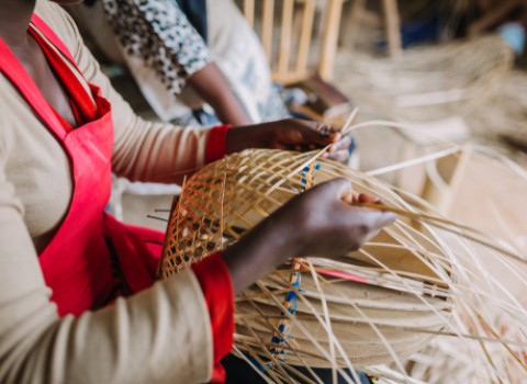 Woman making intricate woven baskets.