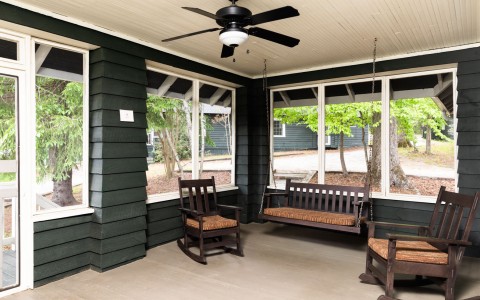 inside a screened in porch with dark walls and benches