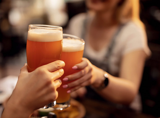 Two people toasting with beer