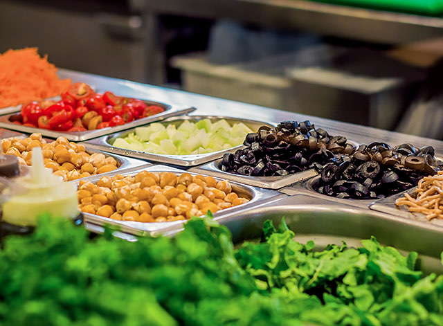 buffet with colorful food including olives, lettuce, and garbanzo beans