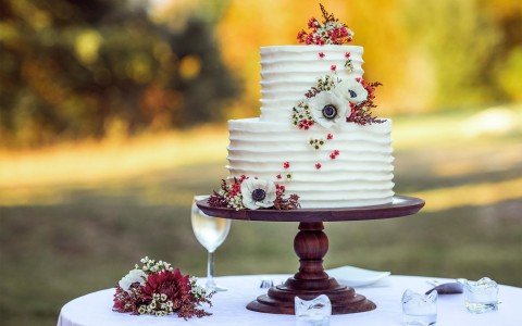 cloup view of a double deck wedding cake and a glass of wine in the table
