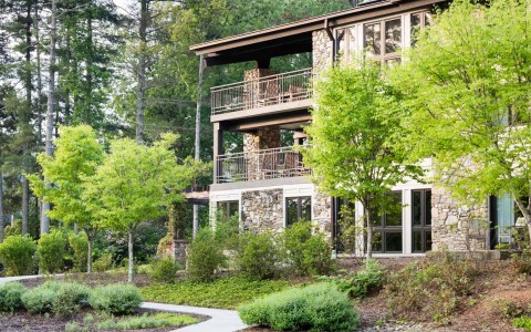 three story lodge with green trees around it