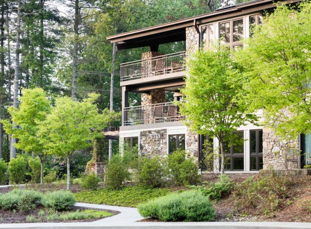 three story lodge with green trees around it
