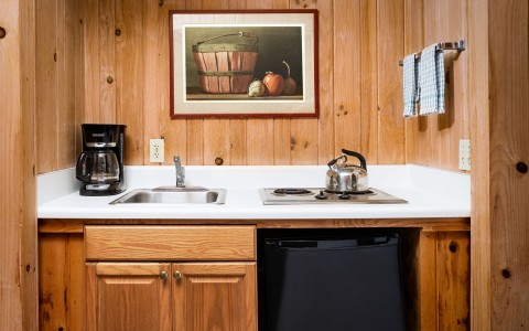 kitchenette with white sink and wooden cabinets