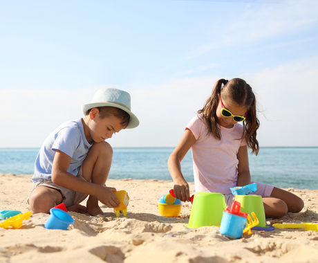 two kids building sandcastles at the beach